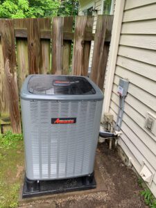 outdoor air conditioning unit beside a picket fence